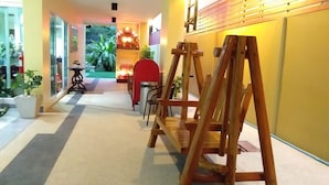 A hallway with a wooden swing set, a small table with a chair, and a decorative fire feature.