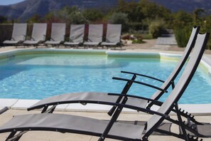 Een seizoensgebonden buitenzwembad en parasols bij het zwembad