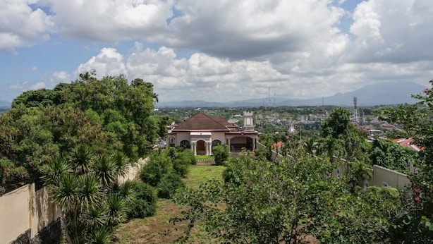 A large building with a central courtyard surrounded by lush greenery. - Rumah Kost MAPLE Winangun (Manado)