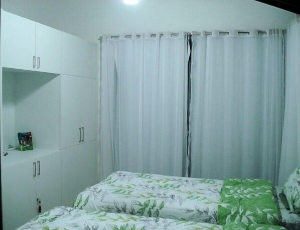 A bedroom with a bed, a wardrobe, and a curtain. - House in condominium by the sea, chicken harbor (high wall)<br> (Porto de Galinhas)