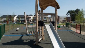 A playground with a slide and climbing structures.