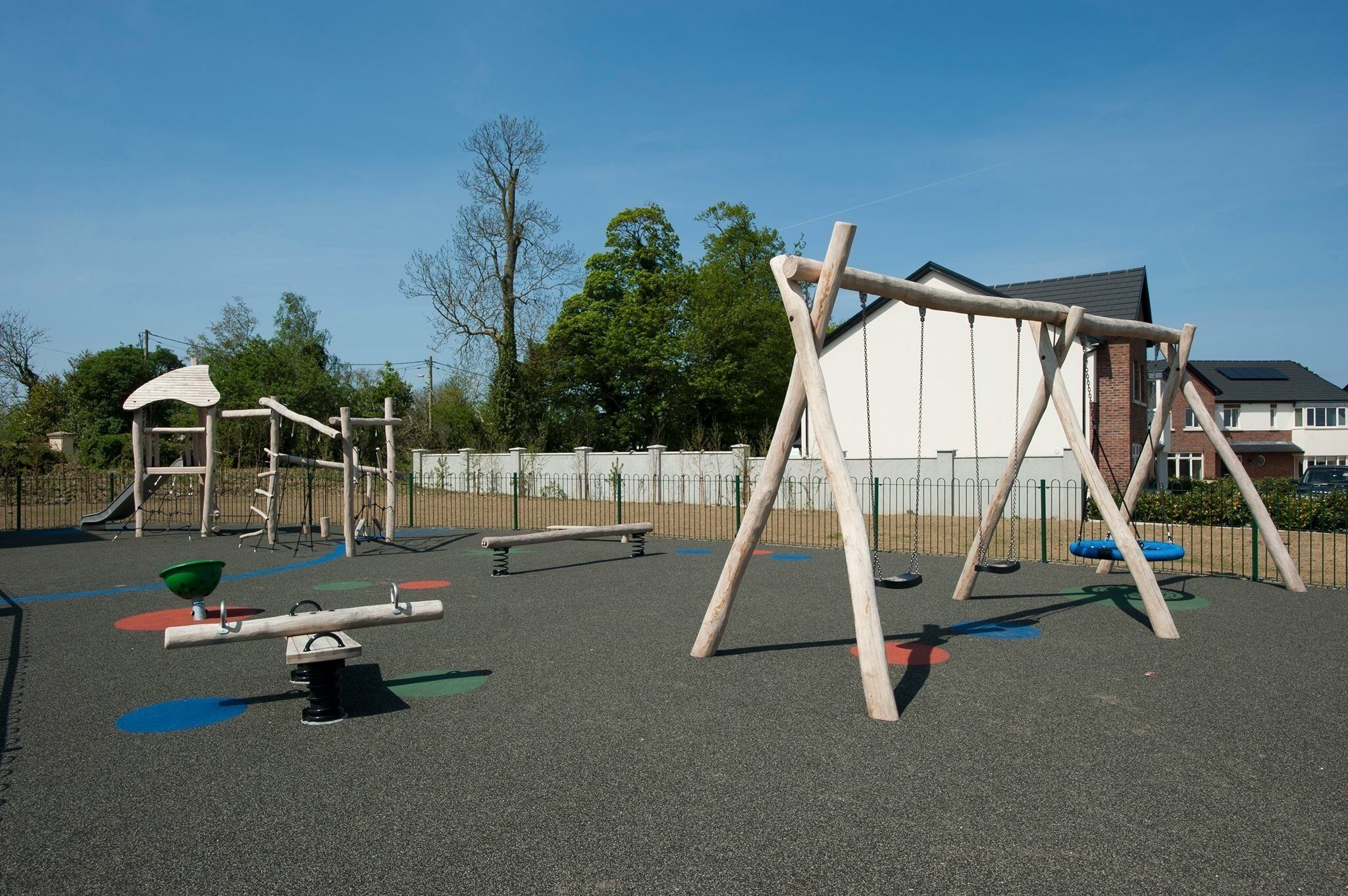 A playground with various equipment including swings, a seesaw, and a climbing structure.