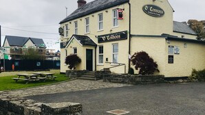 A traditional pub named 'V' Connors with a stone facade, a signboard, and a small front porch.