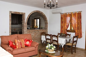 Cozy living room with a sofa, dining table, and brick fireplace.