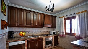 A kitchen with wooden cabinets, a built-in oven, a dishwasher, and a granite countertop.