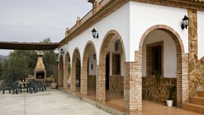 A building with a patio area, outdoor seating, and a stone oven.