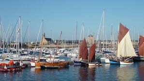 A marina with various boats docked, a clear sky, and a building in the background. - House at Camaret-sur-mer, quiet on fenced 1km to port (Camaret-Sur-Mer)