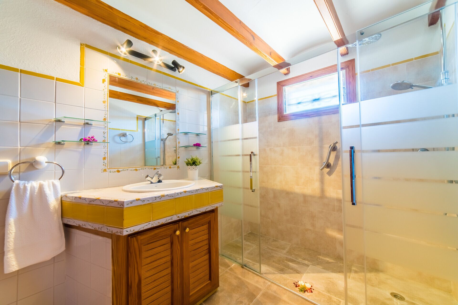 A modern bathroom with a glass shower enclosure, a wooden vanity, and a large mirror.