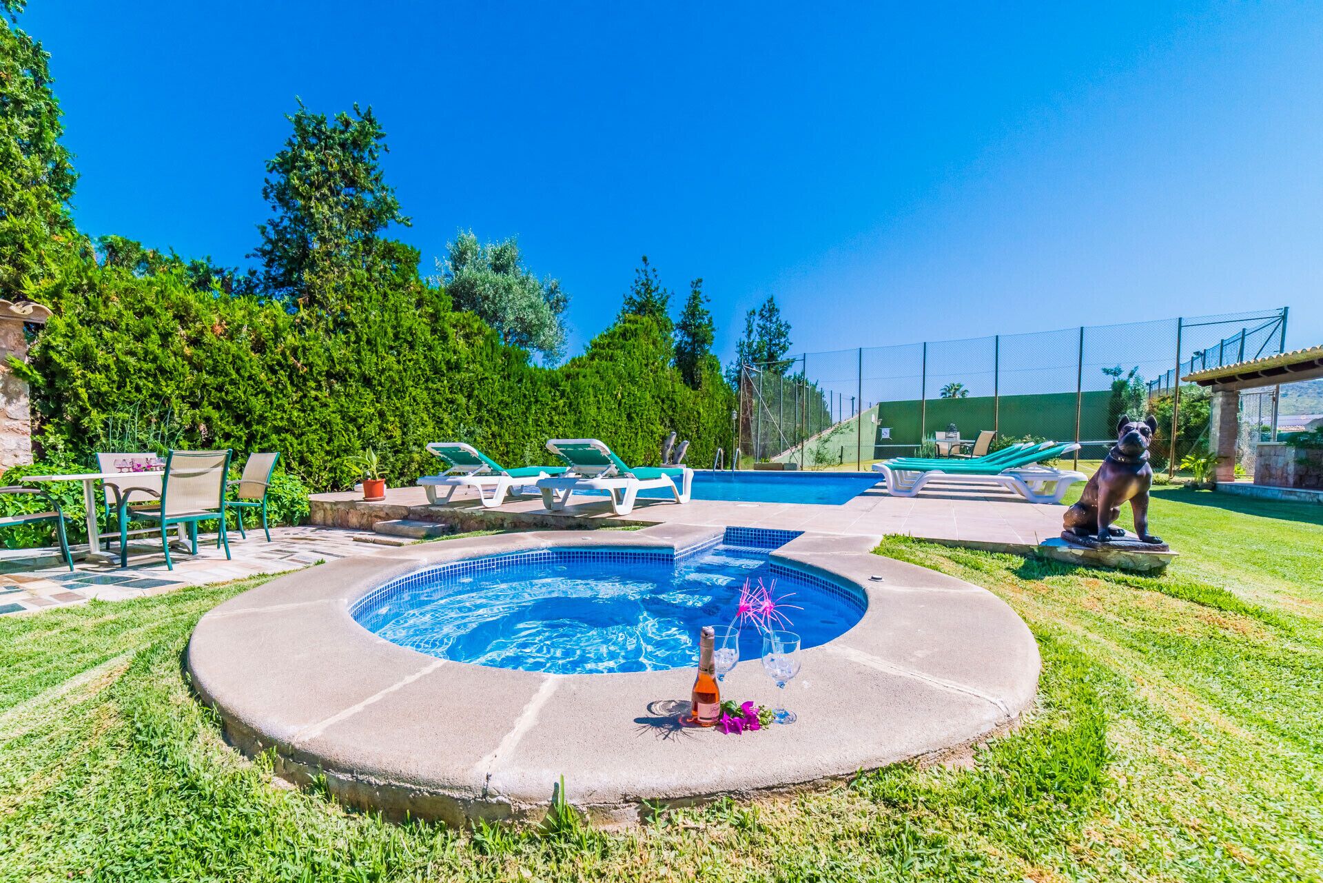 A circular swimming pool with lounge chairs and a statue.