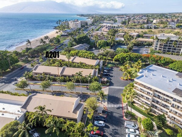 A coastal resort area with multiple buildings, parking lots, and a beach.