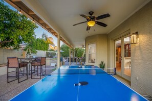 Huge covered patio with outdoor games and a ping-pong table.