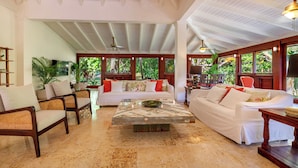 A spacious living area with a white sofa, a wooden coffee table, and a dining table with chairs. - Walking Distance to the Beach (La Romana)