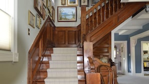 A grand staircase with wooden railings and a carpeted landing. - Beautifully restored Victorian Mountain home furnished with authentic antiques! (Silverton)