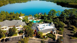 Vista aerea di un resort con un grande lago, diversi edifici e una piscina.