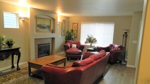 A living room with a fireplace, leather sofas, a coffee table, and a patterned rug. - Upscale Puyallup Home ☆ Near Seattle, Tacoma, Puget Sound, Cascade Mountains (Puyallup)