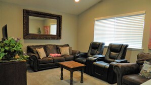 A living room with a brown leather sofa, a matching leather recliner, a wooden coffee table, and a large mirror on the wall. - Upscale Puyallup Home ☆ Near Seattle, Tacoma, Puget Sound, Cascade Mountains (Puyallup)
