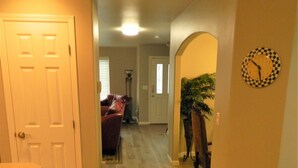 A hallway with a dining table and chairs, a clock on the wall, and a plant. - Upscale Puyallup Home ☆ Near Seattle, Tacoma, Puget Sound, Cascade Mountains (Puyallup)