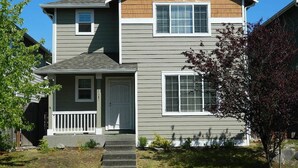 A two-story house with a front porch, a small attached garage, and a well-maintained lawn. - Upscale Puyallup Home ☆ Near Seattle, Tacoma, Puget Sound, Cascade Mountains (Puyallup)