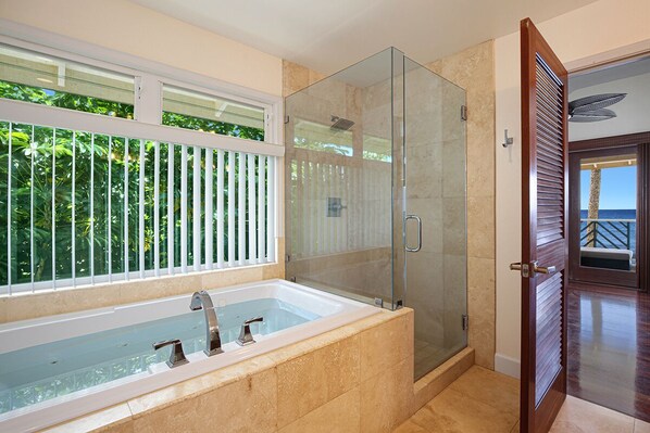 A modern bathroom with a glass-enclosed shower, a large bathtub, and a view of the outdoors through a window with blinds. - Hale Nalu - Beachfront Home Steps from Baby Beach with Spa/AC! (Koloa)