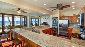 Una cocina moderna con encimeras de granito, electrodomésticos de acero inoxidable y una isla grande.