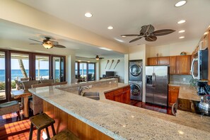 Una cocina moderna con encimeras de granito, electrodomésticos de acero inoxidable y una isla grande.