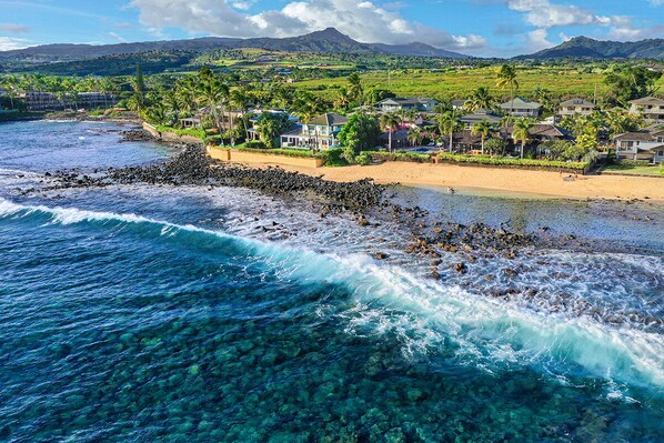 A coastal resort with clear waters, a rocky beach, and houses with a view of the ocean. - Hale Nalu - Beachfront Home Steps from Baby Beach with Spa/AC! (Koloa)