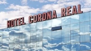 Un hotel con un amplio muro de cristal que refleja el cielo.
