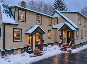 A two-story house with a stone chimney, green trim, and a number '16264' on the front door. - Red Fox Townhouse Private Hot Tub Near Skiing (Windham)