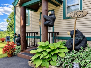 A wooden house with a porch, a welcome sign, and two bear statues. - Red Fox Townhouse Private Hot Tub Near Skiing (Windham)