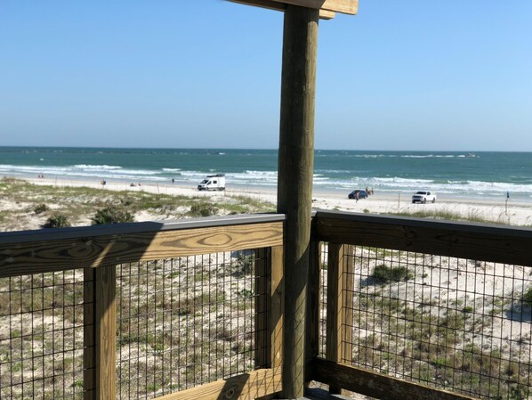 Enjoy the ocean view from this deck overlooking the sandy beach.