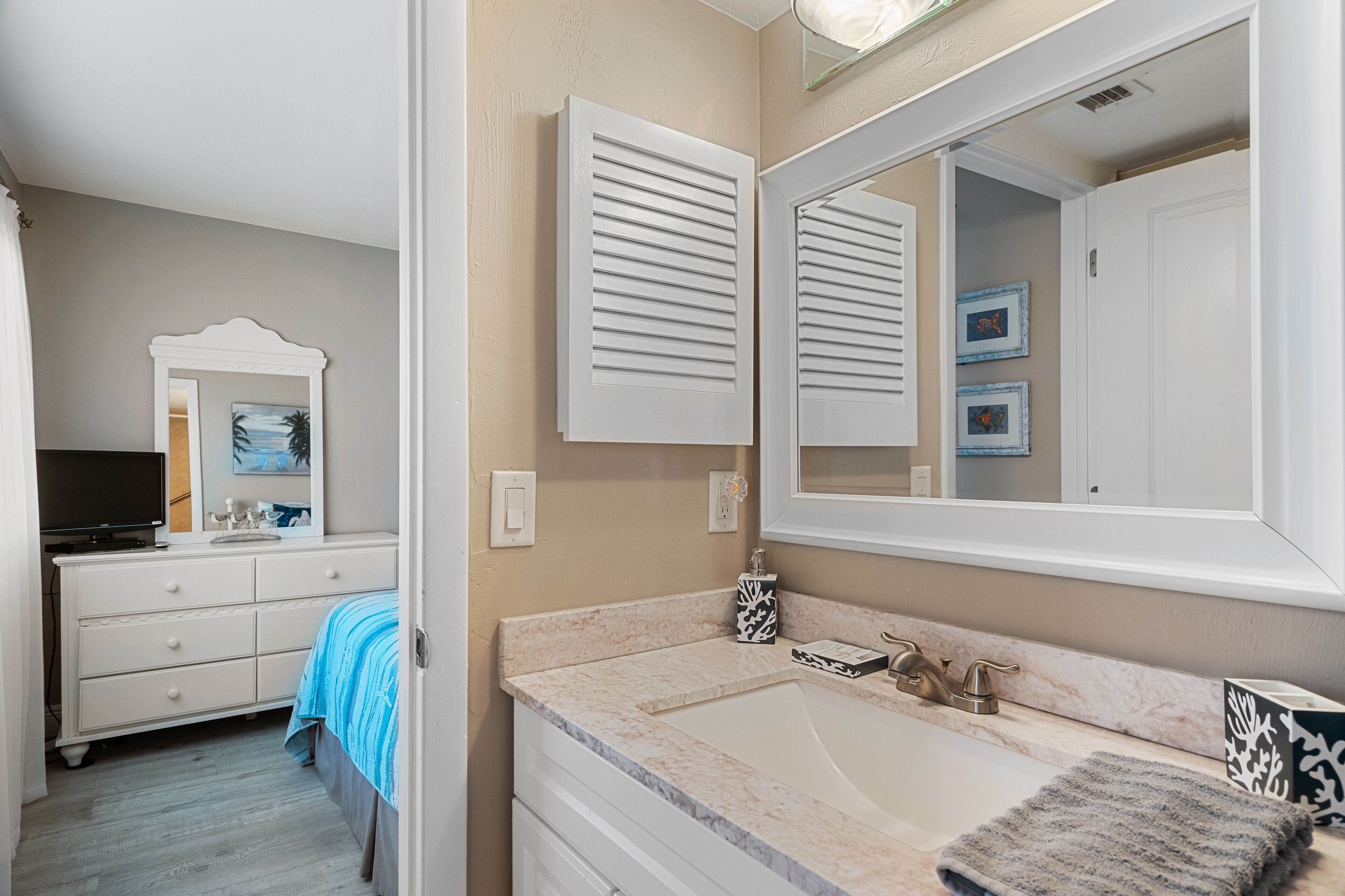 Une salle de bain avec un lavabo, un miroir et un porte-serviettes.