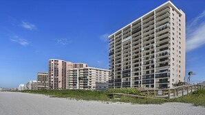 A beachfront hotel with multiple high-rise buildings, a sandy beach, and a wooden walkway leading to the buildings. - Beautiful, updated, oceanfront views!  Gorgeous unit! (Marco Island)