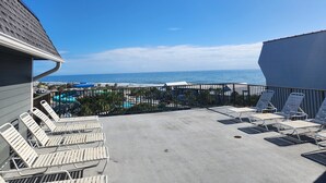 Eine Dachterrasse mit Liegestühlen und Blick auf den Ozean.