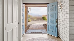 A doorway leading to a patio with a stone pathway and a view of mountains. - Spectacular Views! Heated Pool. Game Room. Private. Spacious. (Fountain Hills)