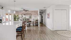 A modern kitchen with a central island, wooden flooring, and white cabinetry. - Spectacular Views! Heated Pool. Game Room. Private. Spacious. (Fountain Hills)