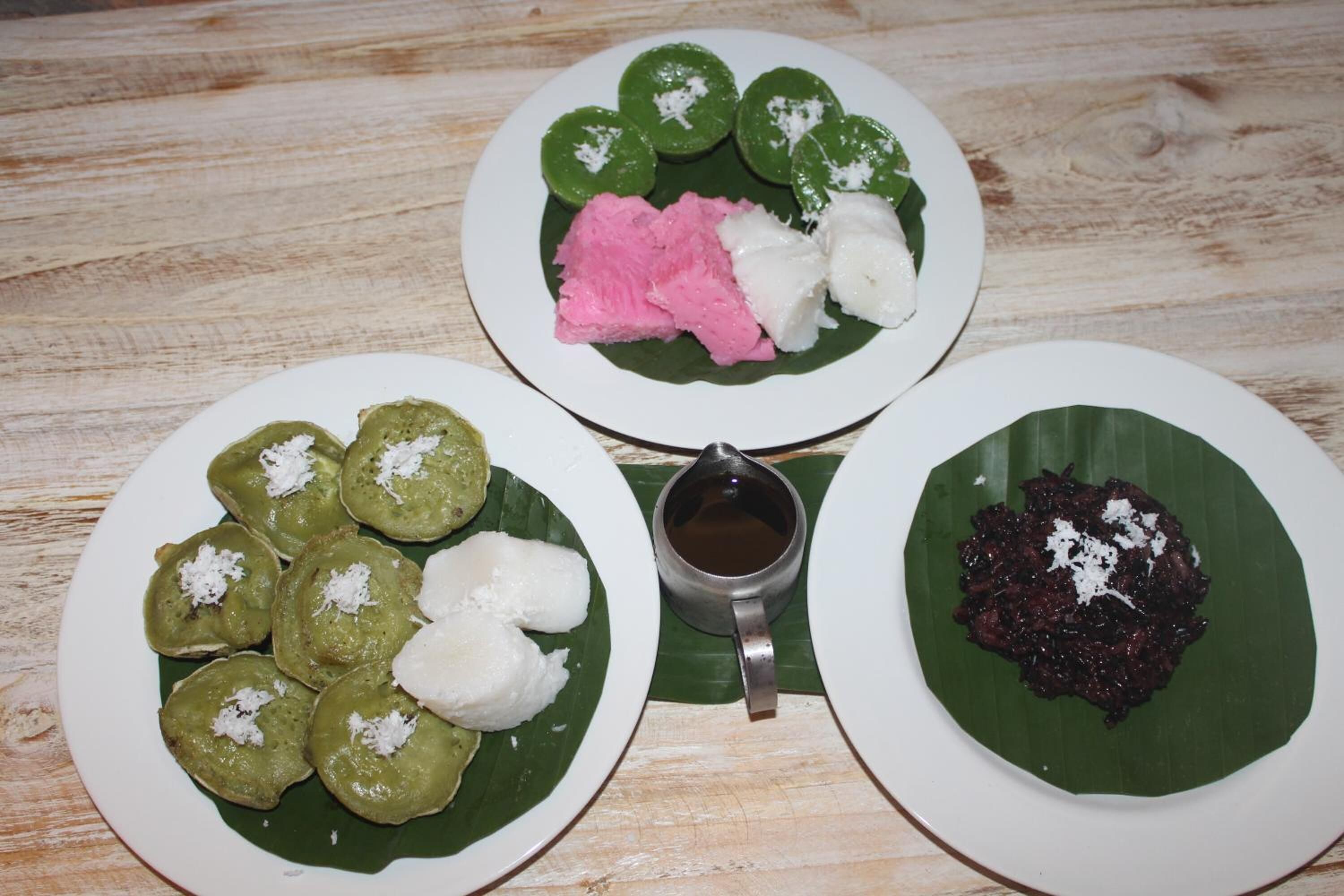 Three plates of food on a wooden table.