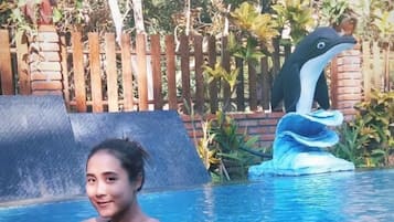 Una piscina al aire libre, sillones reclinables de piscina