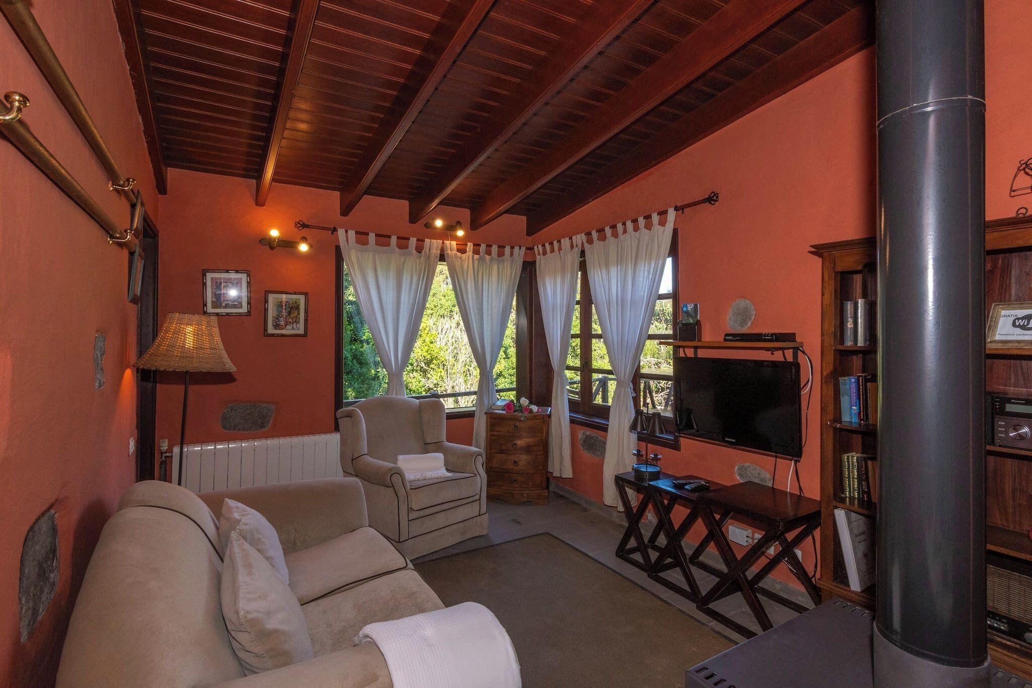A cozy living room with a sofa, armchair, and a television.