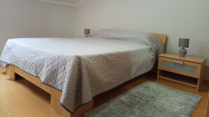 A bedroom with a bed, nightstands, a lamp, and a rug. - Guest Apartment in Santana (Santana)