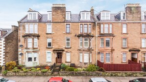 A row of terraced houses with a central entrance, brick construction, and a red fence in front. - Claymore Apartment, Brook Street, central Broughty Ferry, Dundee (Dundee)