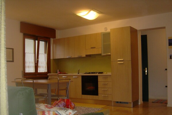 Cozy living space with a kitchenette, dining table, and sofa.