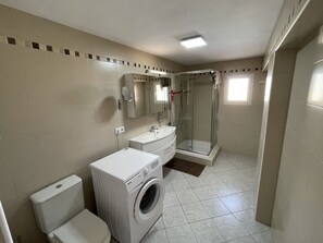 Bathtub, hair dryer, towels, shampoo
