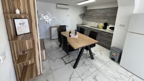 A modern kitchen with a wooden dining table, black chairs, and a built-in oven. - Villa Romeo Calpe for groups and large families with 2 pools (Calpe)