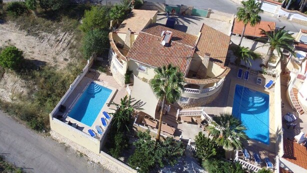 A two-story building with a swimming pool, a covered patio, and a view of the surrounding landscape. - Villa Romeo Calpe for groups and large families with 2 pools (Calpe)