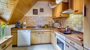 Eine Küche mit Holzausstattung, einem Geschirrspüler, einem Herd und einem Waschbecken.