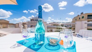 Ein Tisch mit einer Cristal Bialy Flasche, zwei Gläsern, einer Nussmischung und einer Serviette auf einer blauen Matte.