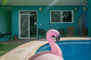 A swimming pool with a pink flamingo decoration.