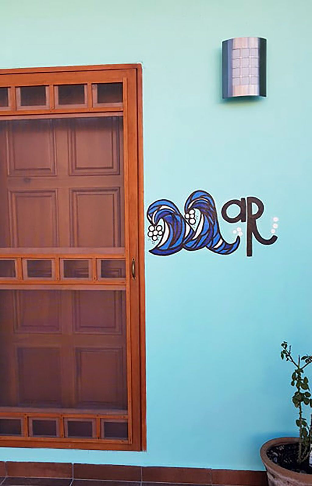 Une pièce avec une porte en bois et un mur orné d’un motif décoratif bleu et blanc.