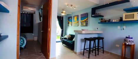 A compact living space with a kitchenette, a sofa, and a dining area.