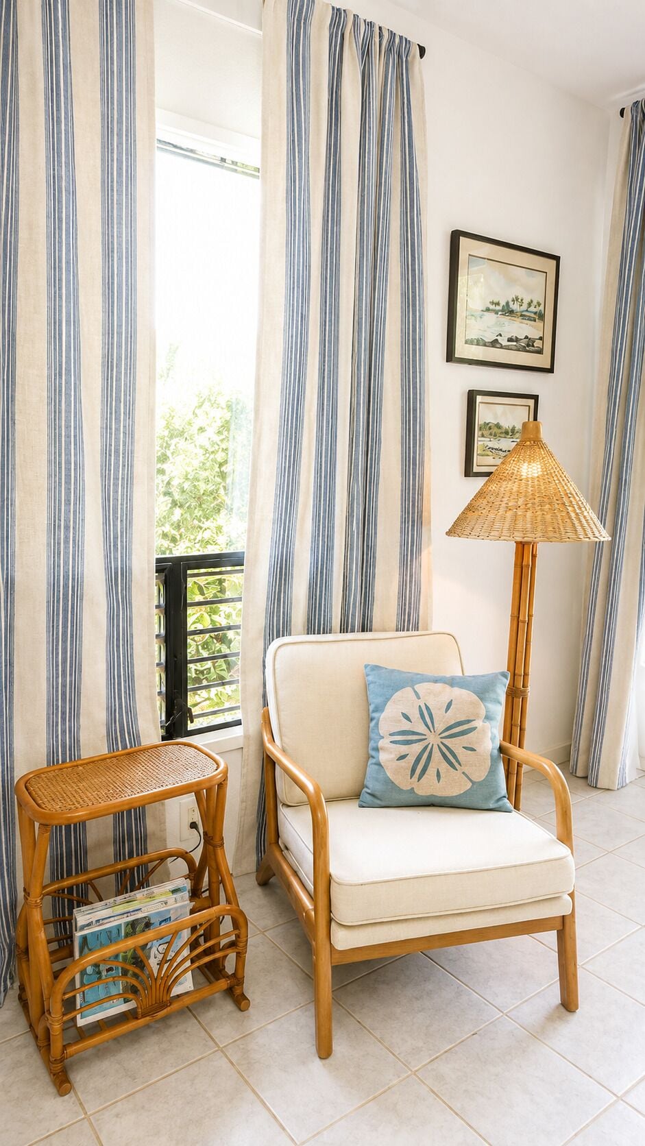 A room with a wicker chair, a small table with magazines, and a floor lamp.